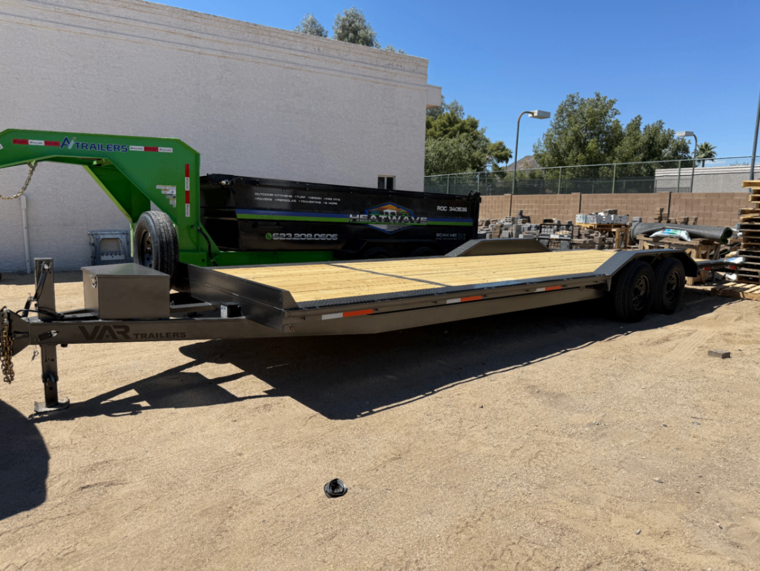 Long car hauler trailer with a fresh wood deck and gray frame, seen from above.